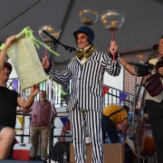 photo of a man in a striped suite balancing several bowls on his hands and head